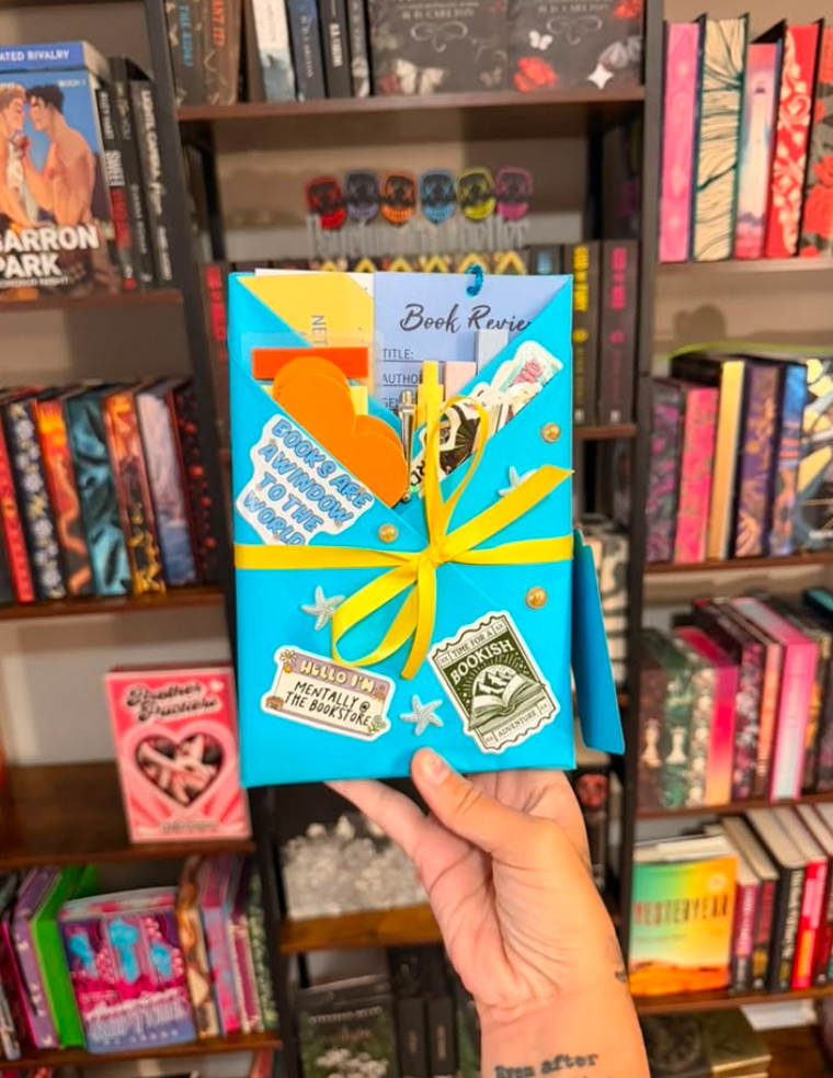 Turquoise-wrapped blind date book with yellow ribbon and bookish stickers