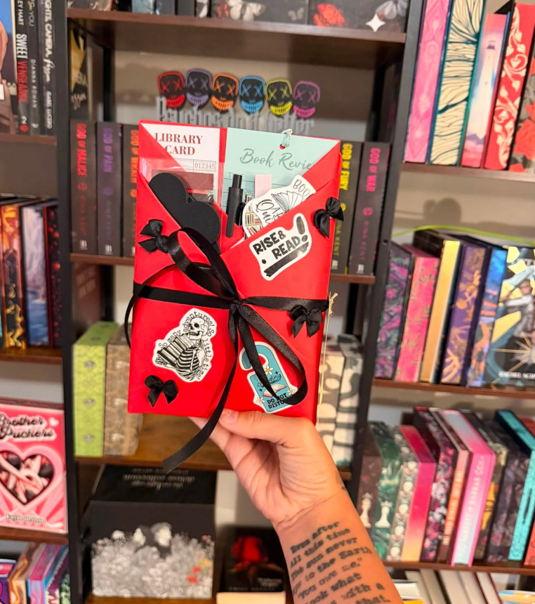 Red-wrapped blind date book with black bows and Rise & Read sticker